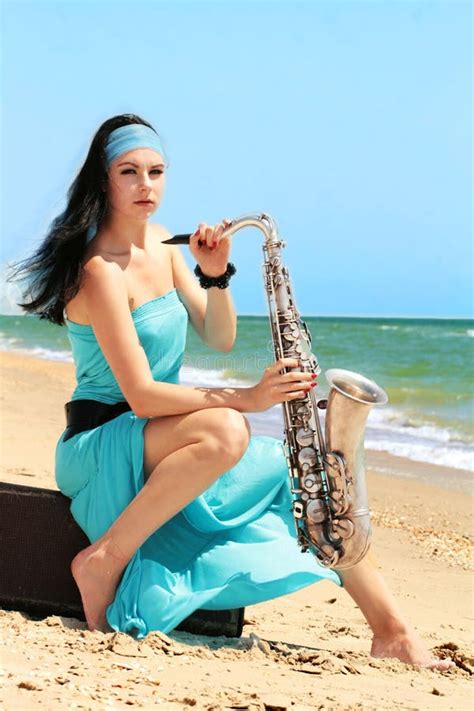 Femme Attirante Sexy Avec Le Saxophone Posant Sur Le Fond Rouge Jeune