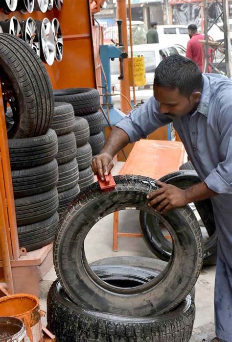 A Worker Polishing Old Tires At His Work Place