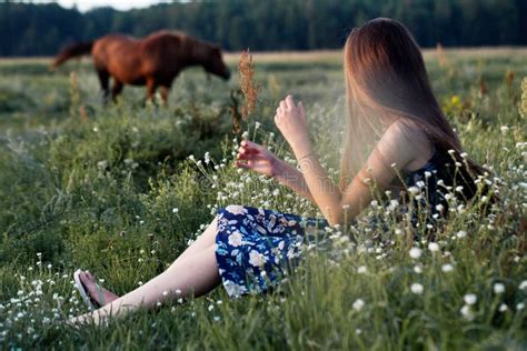 Pretty Teenager Girl With Healthy Long Hair Sitting On The Meadow In Summer Day Stock Image