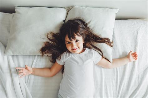 Une Petite Fille Aux Cheveux Noirs Dort Dans Son Lit Un Enfant Est