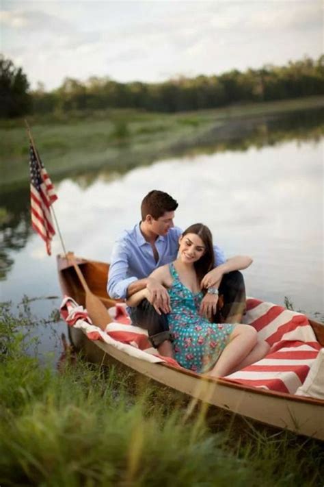 A Man And Woman Are Sitting In A Boat On The Water With An American Flag