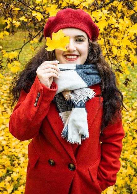 La Belle Femme Couvre Son Visage De Feuilles Automnales Photo Premium