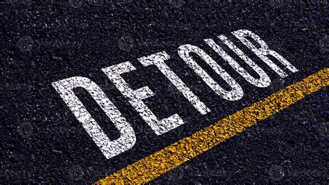 Detour written and yellow line on the road in middle of the asphalt