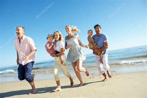 Família de várias gerações desfrutando de férias na praia fotos