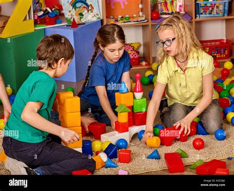 Children Building Blocks In Kindergarten Group Kids Playing Toy On