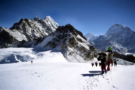 Sherpas Y Escaladores Que Cruzan Un Glaciar De Himalayam Imagen De