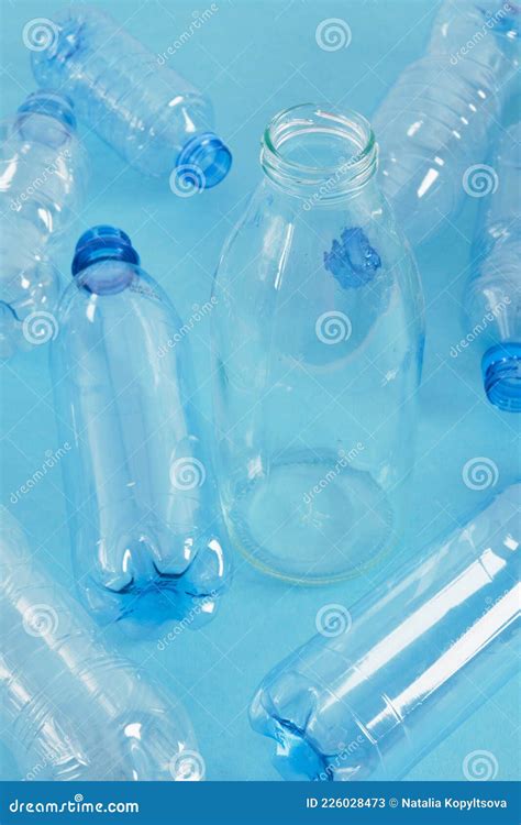 Une Bouteille En Verre Parmi Plusieurs Bouteilles En Plastique Sur Fond