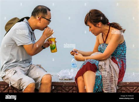 Couple Having Sunset Drinks Snacks On The Mekong Riverfront Promenade