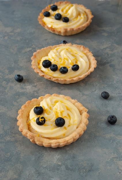 Premium Photo Lemon Curd Tarts With Blueberries On A Grey Background