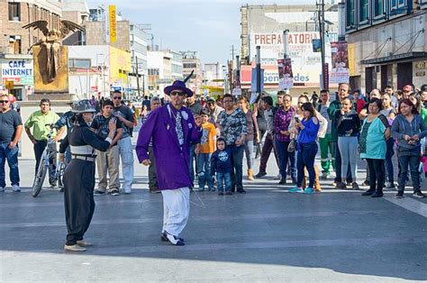 a man in a purple suit is walking down the street while people are ...