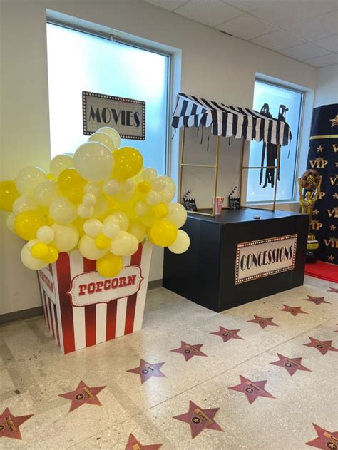 A Popcorn Box Filled With Yellow Balloons Sitting On Top Of A Tiled