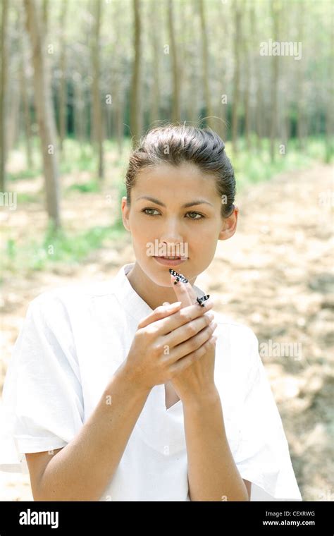 Female Brunette Hair Off Her Face Wearing A White Top Standing In