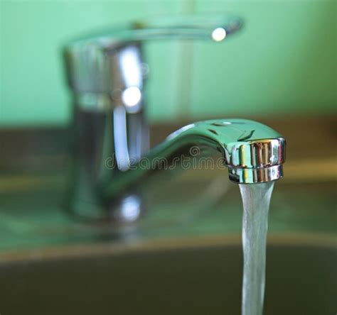 Water Flows From The Tap Faucet With Water That Flows Into The Kitchen