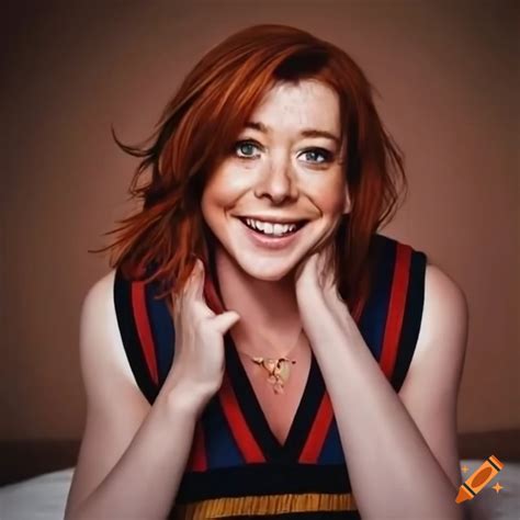 Alyson Hannigan Sitting On A Bed Wearing A Striped Sweater Vest And