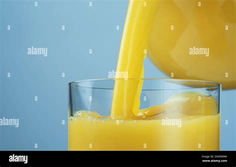 Orange Juice Pouring From Jug Into Glass Stock Photo Alamy