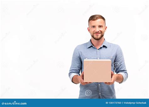 Casual Young Man Holding A Box Isolated On A White Background Stock