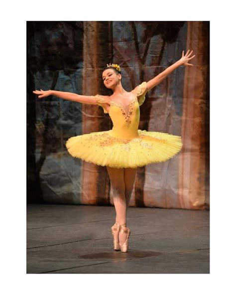 A Ballerina In Yellow Is Performing On Stage