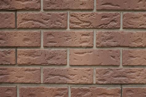 Closeup Of Chocolate Brown Brick Veneer Wall With Grey Mortar Joints