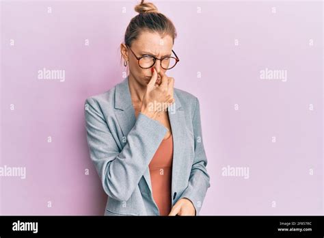 Beautiful Caucasian Woman Wearing Business Jacket And Glasses Smelling