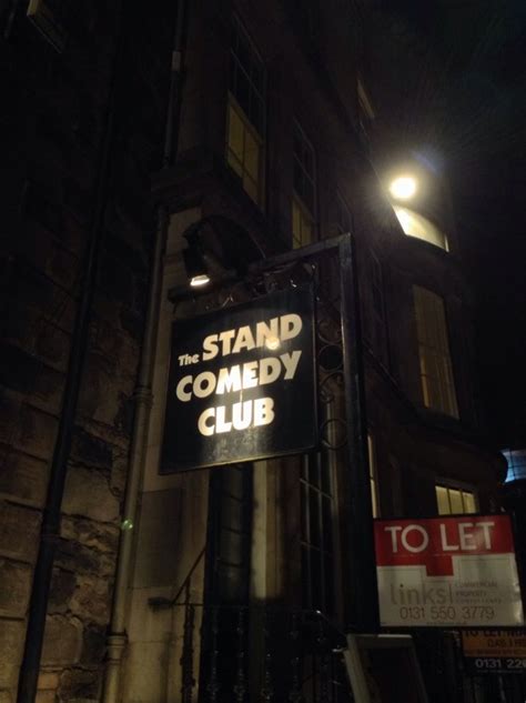 the stand comedy club sign is lit up at night