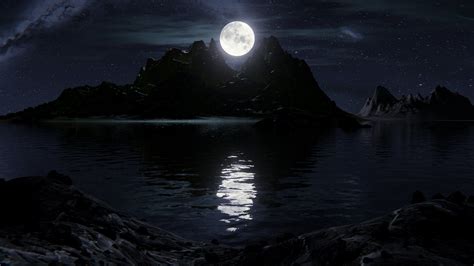 A Full Moon Is Seen Over An Island In The Middle Of The Ocean With Rocks