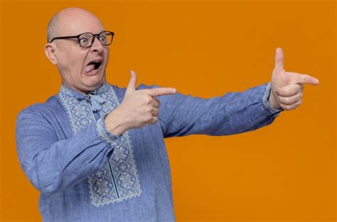 Impresionado hombre eslavo adulto en camisa azul y con gafas ópticas