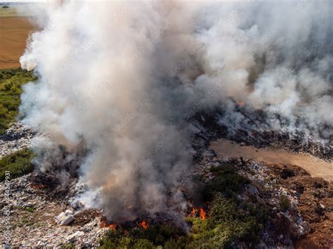 Top view of garbage on fire. Burning rubbish on town dump polluting air ...