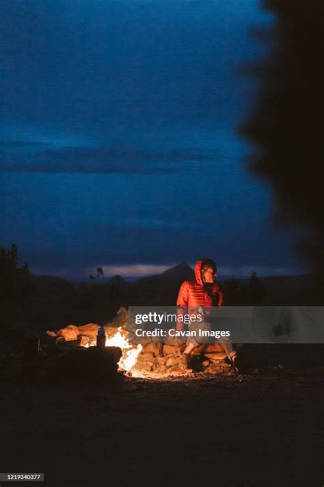 Female Hiker Sitting Around A Campfire In The Desert Of Utah Near Moab