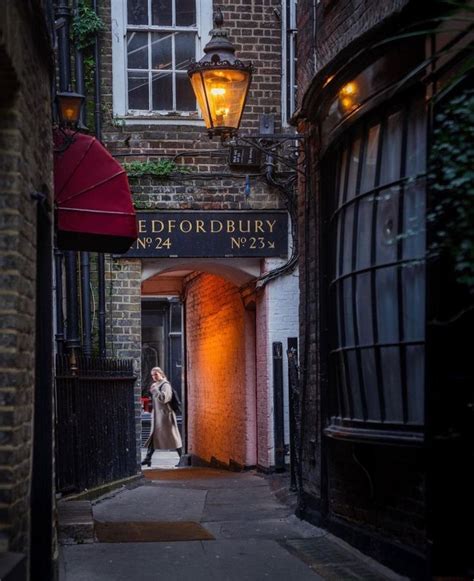 A Bride And Groom Are Standing In An Alleyway Between Two Brick