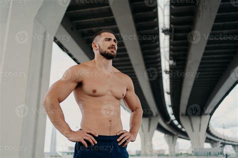 Athletic Male Fitness Model Keeps Hands On Waist Poses With Muscular