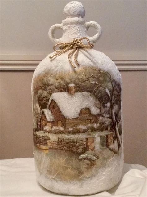 A Glass Bottle Covered In Snow Sitting On Top Of A White Tableclothed Table