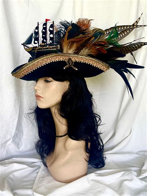 A Womans Head Wearing A Black Hat With Feathers And A Sailboat On It