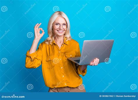 Photo Of Blonde Lovely Senior Lady Hold Netbook Show Okey Symbol Wear