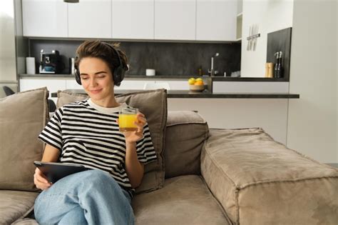 Free Photo Portrait Of Woman In Headphones Sitting On Sofa With