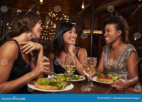 Three Female Friends Eating Dinner Together At A Restaurant Stock Image