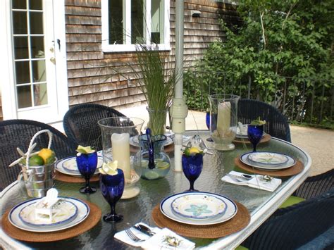 An Outdoor Table Set With Plates Glasses And Vases On The Outside