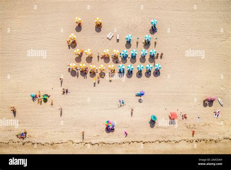 Top Down Aerial View Of Beach With Colourful Umbrellas And People