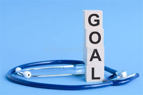 Goal Word Written On Wooden Blocks And Stethoscope On Light Blue