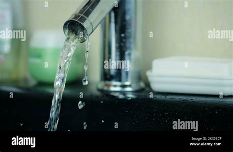 Powerful Stream Of Water Flowing From An Aluminum Tap In The Bathroom