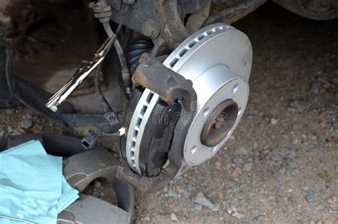 Replacement of the Brake Disc at the Car in Domestic Conditions. the Car Repairman Removes the ...