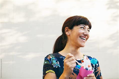 Smiling Mature Woman Eating An Ice Cream Outdoors By Stocksy