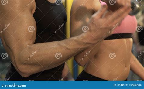 Personal Trainer Helping Young Fit Woman To Lift Dumbbells In Proper Way At Gym Stock Video