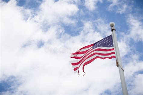 Weathered American Flag On A Pole With Blue Sky Background Old Flag