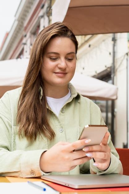 Donna Con Colpo Medio Che Tiene Il Telefono Foto Gratis