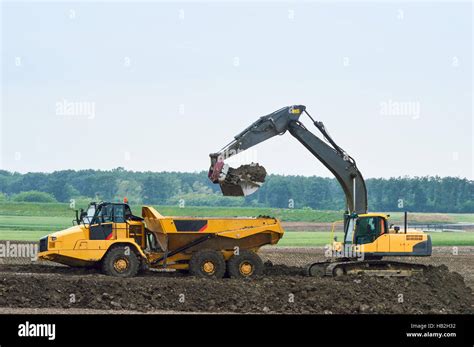 Excavator Loads Earth On Dump Truck Stock Photo Alamy