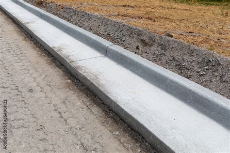 Road Construction Details Extruded Concrete Curb Beside Freshly