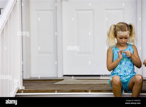 A Cute Little Girl Sitting By Front Door Stock Photo Alamy