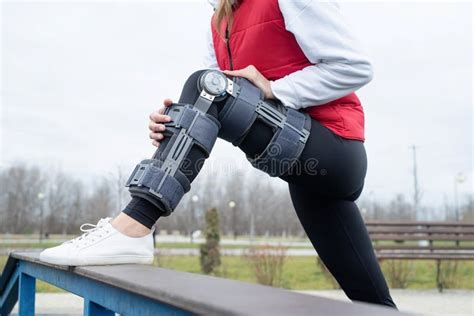 Woman Wearing Knee Brace Or Orthosis After Leg Surgery Working Out In