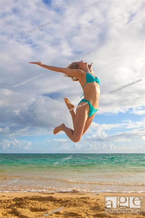 Woman In A Bikini Leaping In The Air On The Beach Kailua Island Of