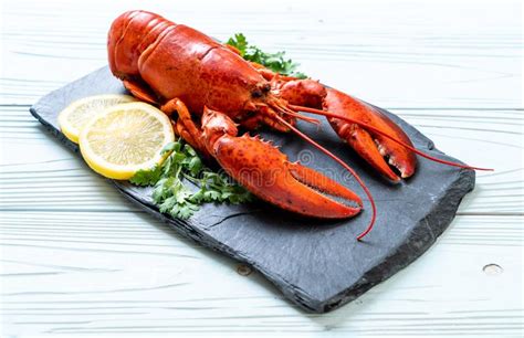 Lobster With Vegetable And Lemon On Black Slate Plate Stock Image